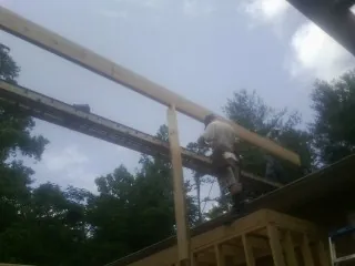 Carpenter setting a ridge beam over a new addition frame — Ice Dam Removal by Roofing Brothers in Esmond