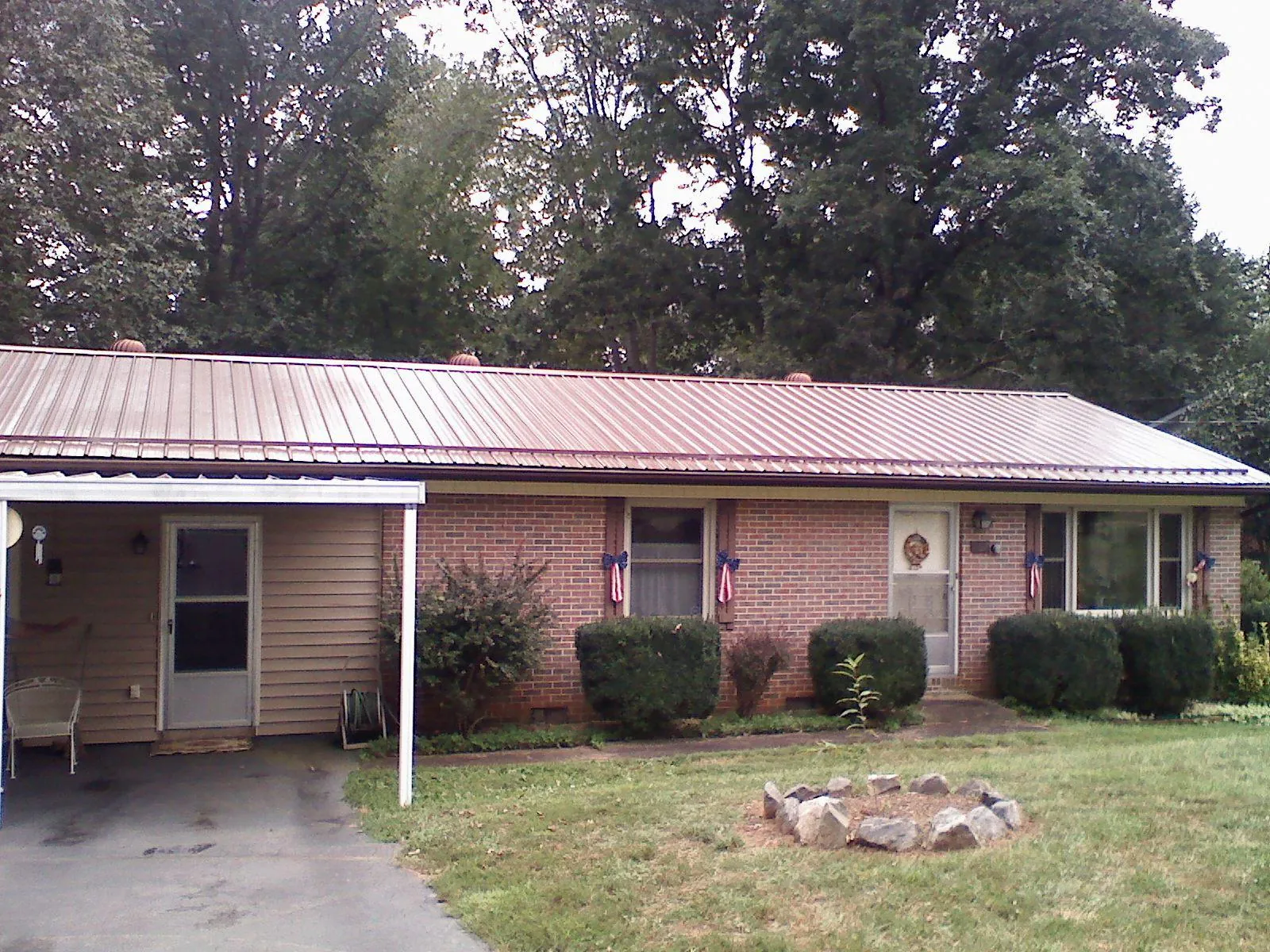Bronze metal roof and carport on a brick ranch home — Roof Repair work by our crew in Esmond