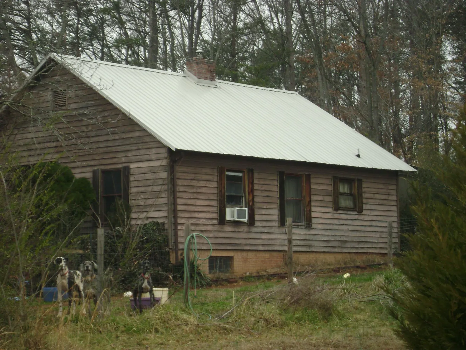 White metal roof on an old wood sided farmhouse, from a Metal Roof Installation job in Esmond
